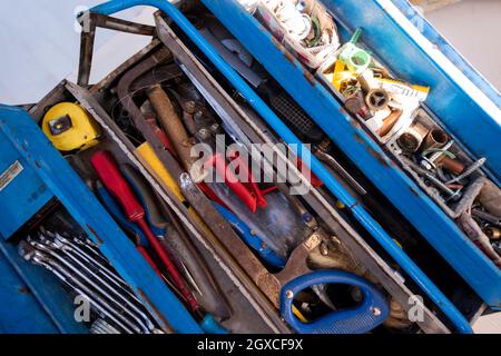 toolbox full of hand tools on real dusty floor background at construction site Stock Photo