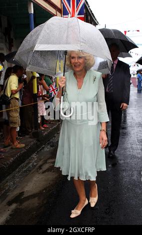 Camilla, Duchess of Cornwall shelters from the rain under an umbrella as she arrives in Soufriere, St. Lucia on March 7, 2008. Stock Photo