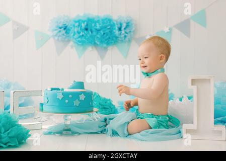 A one-year-old boy tries his first birthday cake. Anniversary Party Stock Photo