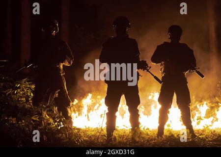 special marines military forces squad soldiers group portrait after finished mission complete fire in background Stock Photo