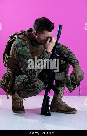 sad soldier has psychological problems holding his head in a squatting position Stock Photo