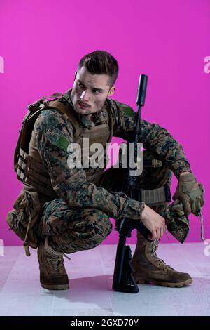 sad soldier has psychological problems holding his head in a squatting position Stock Photo