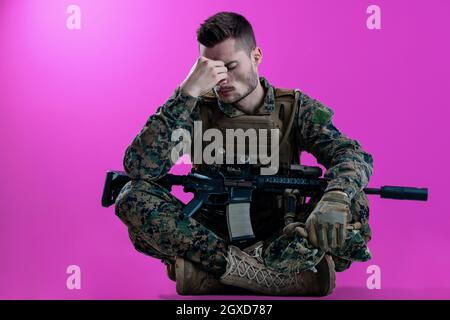 sad soldier has psychological problems holding his head in a squatting position Stock Photo