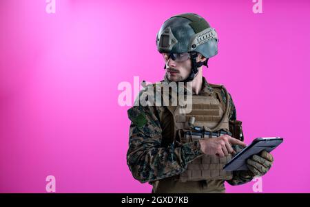 soldier using tablet computer hands closeup pnk background Stock Photo