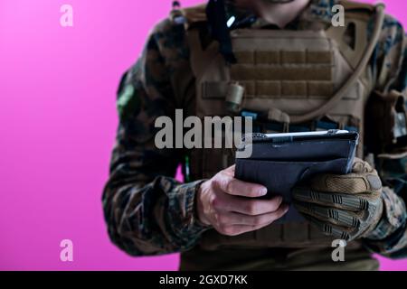 soldier using tablet computer hands closeup pnk background Stock Photo