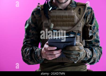 soldier using tablet computer hands closeup pnk background Stock Photo