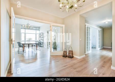 Interior of contemporary spacious apartment with hallway and dining room with table and chairs near window Stock Photo
