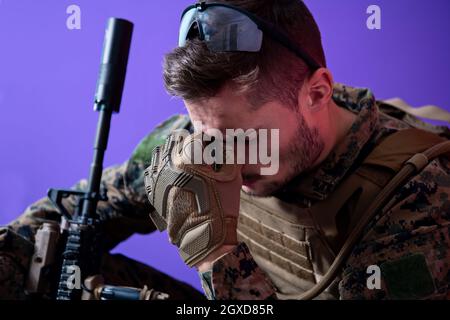 sad soldier has psychological problems holding his head in a squatting position Stock Photo