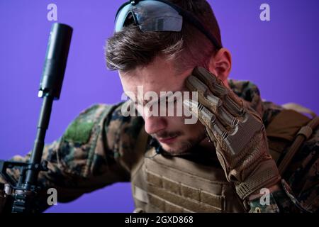 sad soldier has psychological problems holding his head in a squatting position Stock Photo