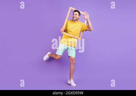 Full length body size photo man waving hand keeping wooden frame isolated pastel violet color background Stock Photo