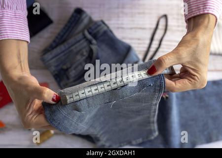 Using measuring tape. Seamstress is in her office that is with different  clothes 15461389 Stock Photo at Vecteezy