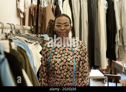 Confident young African female fashion designer standing in her studio Stock Photo