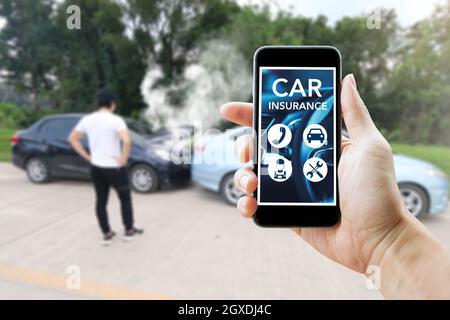 Man using smart phone for car insurance after accident. Outdoor and closeup. Stock Photo