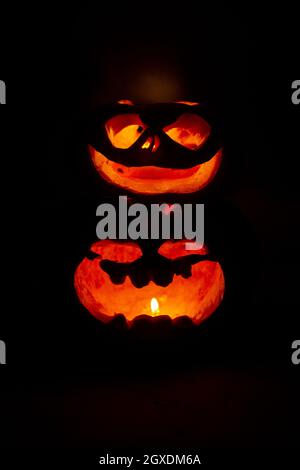 two glowing pumpkins with faces in the dark Stock Photo