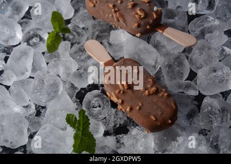 Popsicle chocolate ice cream with almonds on ice cubes background Stock Photo