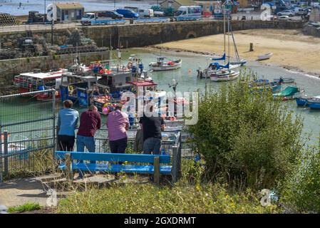 A group of male holidaymakers relaxing and looking out over Newquay Harbour in Cornwall. Stock Photo
