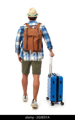 Man from behind with suitcase and backpack Stock Photo