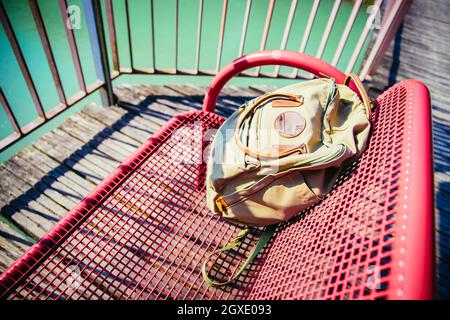 Vintage backpack is lying on red bench Stock Photo