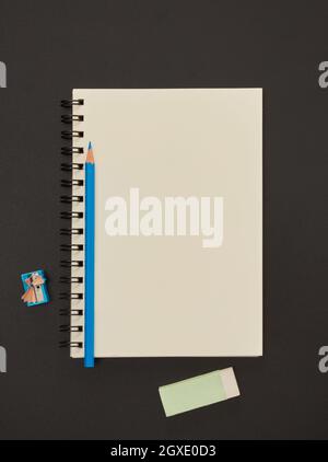 Blank paper notepad and school supplies on blackboard Stock Photo