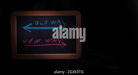 Old way or new way written on chalkboard - dark background and copyspace Stock Photo