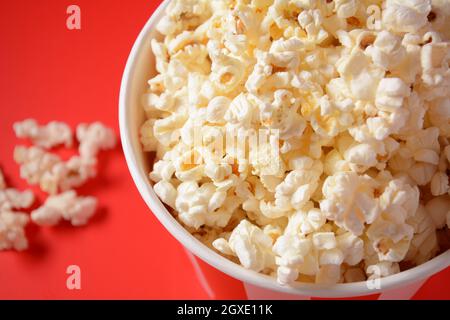 Buckets with delicious popcorn on red background. Spilled popcorn Stock Photo