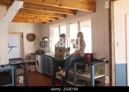 Happy caucasian mature couple drinking coffee in the sunny kitchen Stock Photo