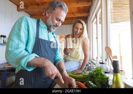 Happy caucasian mature couple cooking together in the modern kitchen