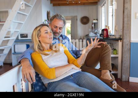 Happy caucasian mature couple sitting and talking in the kitchen Stock Photo