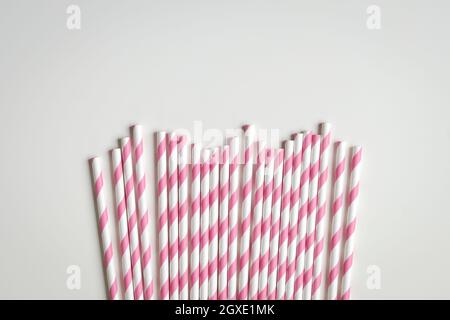 Pink stripe paper straws on white background. Copy space. Stock Photo