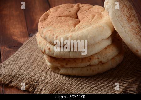 A stack of pita breads. Pita bread on wooden board, Arabic bread, soft baked flatbreads. Popular Israeli food Stock Photo