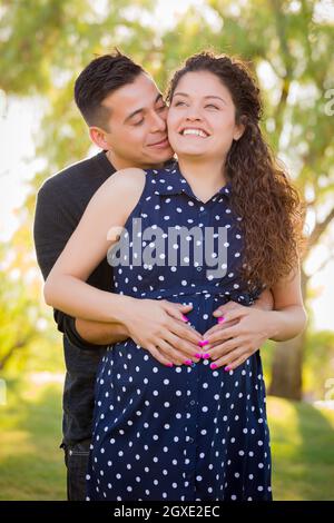 Happy Hispanic Man Hugs His Pregnant Wife Outdoors At The Park Stock ...