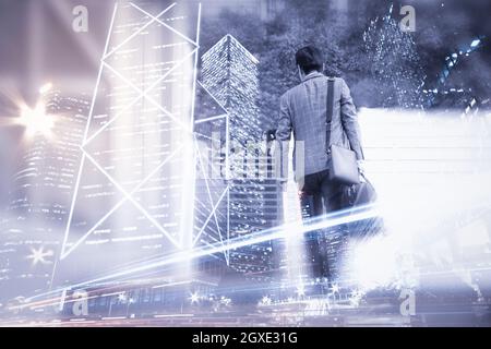 Back view of businessman carrying bags and city with skyscrapers. Double exposure effects. Stock Photo