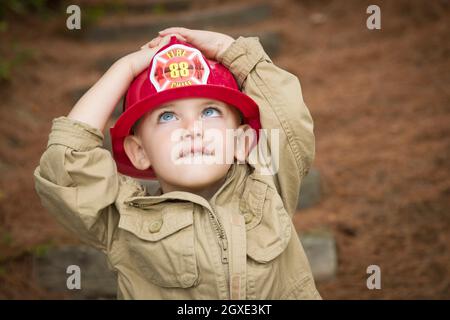 Happy Adorable Child Boy with Fireman Hat Playing Outside. Stock Photo