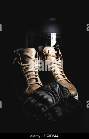 Safety motorcycle accessories. Leather gloves, helmet and shoes on black background. Stock Photo