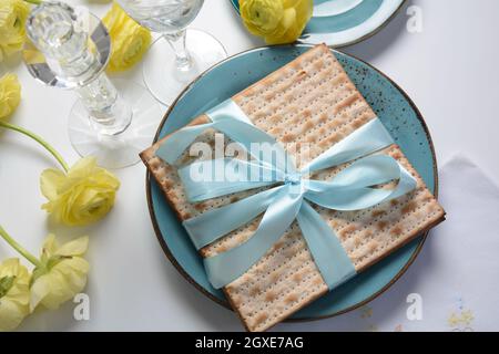 Table served for Passover (Pesach) indoors, with matzah bread as symbolic Pesach (Passover Seder) item. Stock Photo