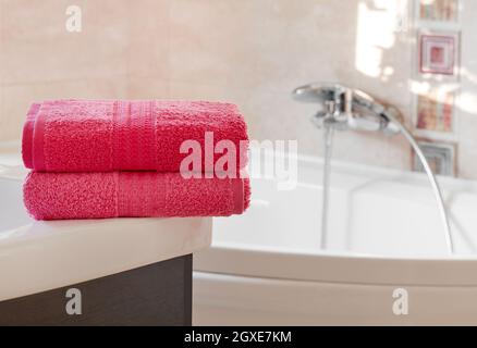 Folded pink towels in bathroom Stock Photo