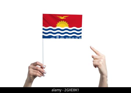 A beautiful female hand holds a Kiribati flag to which she shows the finger of her other hand, isolated on white background. Stock Photo