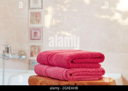 Folded pink towels in bathroom Stock Photo