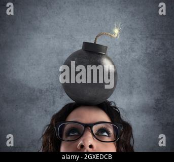 Businesswoman stunned by strong headache with a big bomb over the head Stock Photo