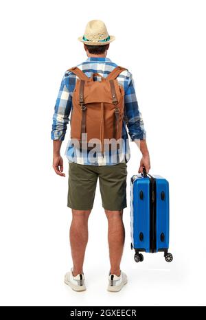 Man from behind with suitcase and backpack Stock Photo
