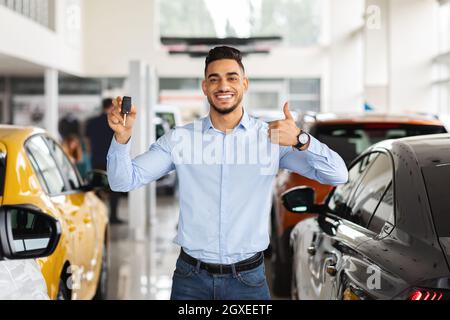 Handsome arabic guy showing car key and thumb up Stock Photo