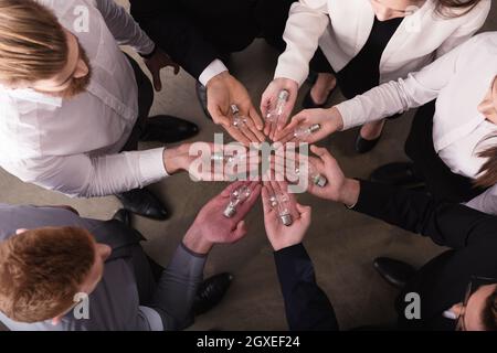 Teamwork and brainstorming concept with businessmen that share an idea with a lamp. Concept company startup Stock Photo