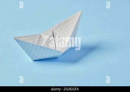 Paper boat on blue background Stock Photo