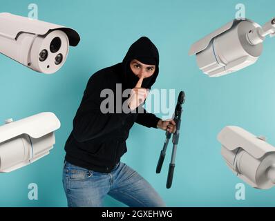 Thief with balaclava was spotted trying to steal from the video surveillance system. Stock Photo