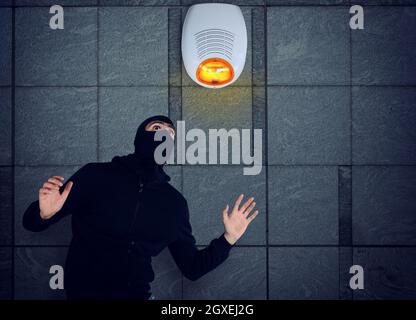 Thief with balaclava was spotted trying to steal in a apartment from the security alarm system. Stock Photo