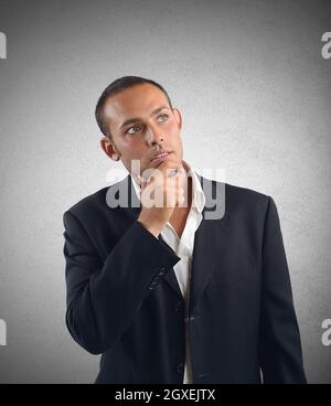 Businessman reflects on what decision to take Stock Photo