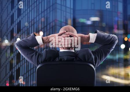 Businessman that relaxes in office and think about the future of the company. double exposure Stock Photo
