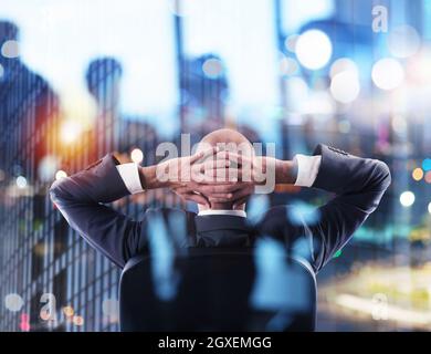 Businessman that relaxes in office and think about the future of the company. double exposure Stock Photo