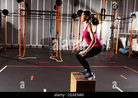 woman jumping box. Fitness woman doing box jump workout at cross fit gym  Stock Photo - Alamy