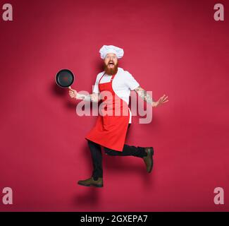 Man chef is scared for something. burgundy background Stock Photo
